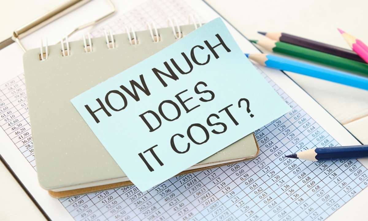 How Much Does it Cost write on sticky note isolated on wooden table