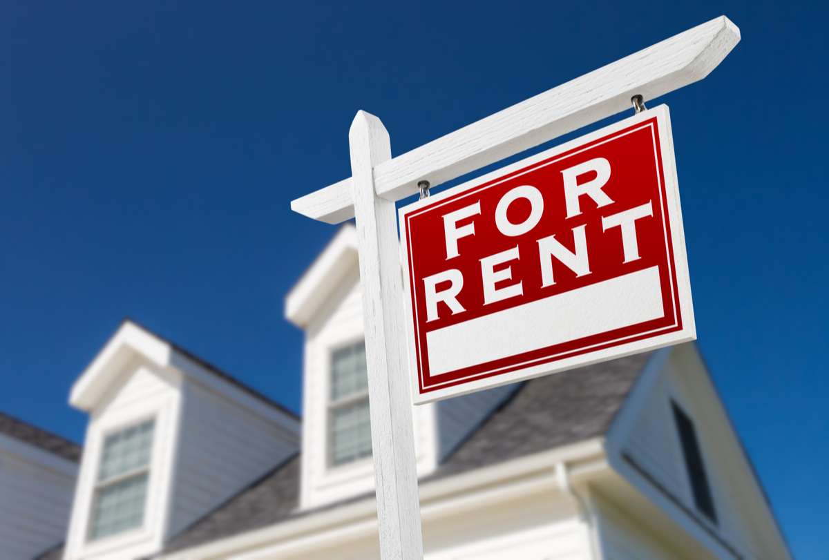 Right Facing For Rent Real Estate Sign In Front of House and Deep Blue Sky