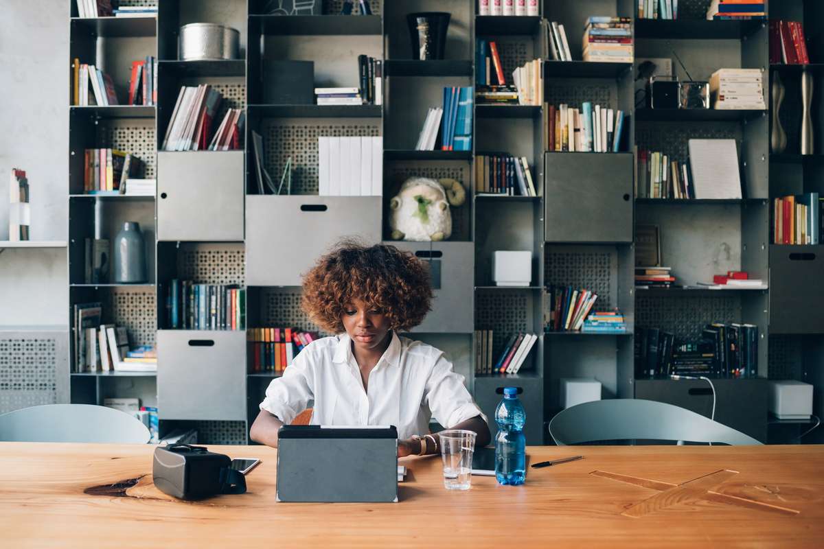 Young black student working with tablet on a project in coworking