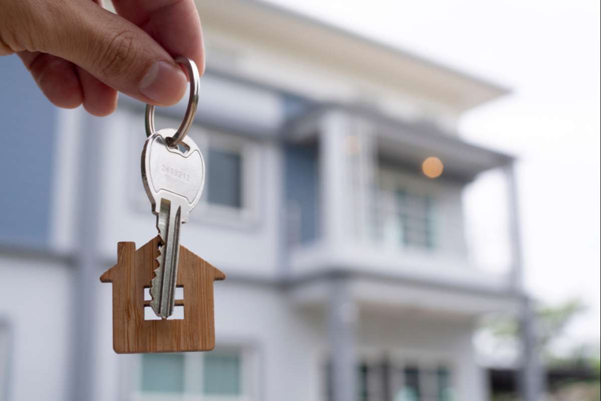 The owner holds a new home key from a real estate dealer
