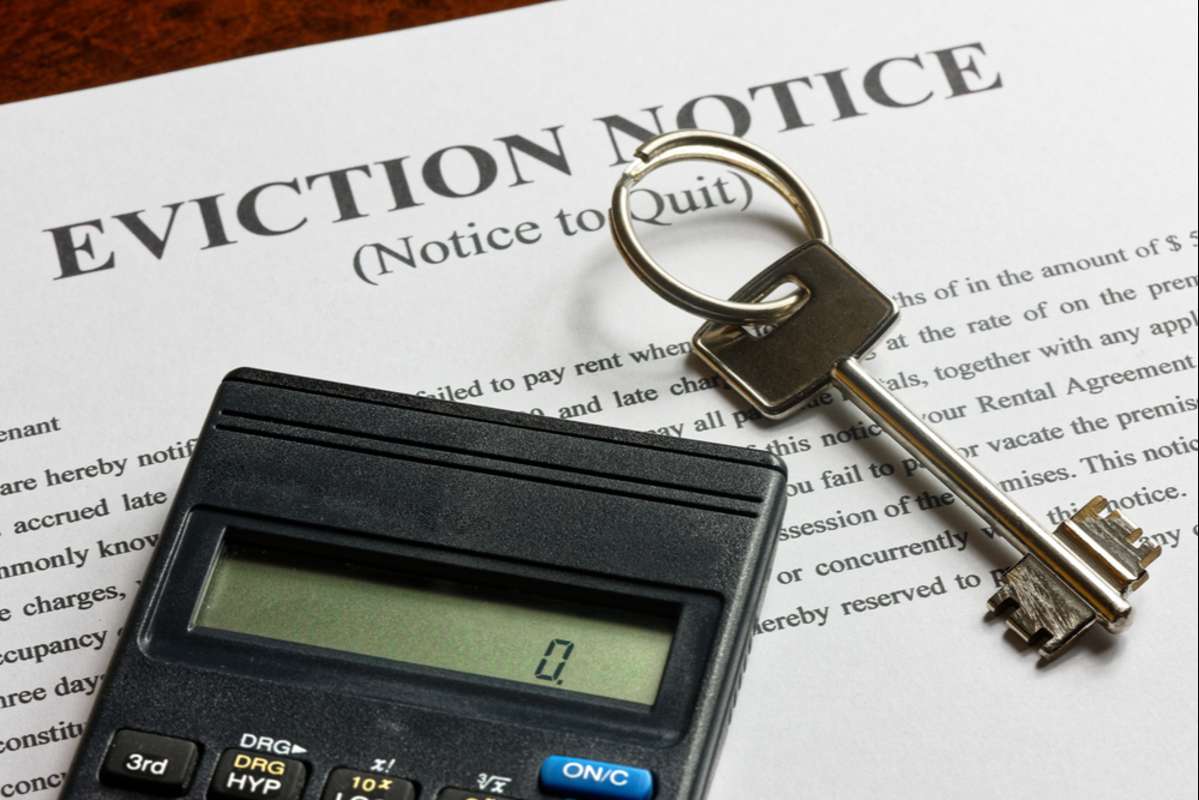 apartment key and calculator on top of the eviction note (R) (S)